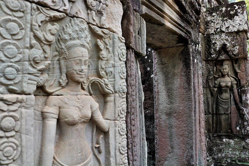 A stone carving of a figure with a headdress, a lotus flower, and a curved staff. 5