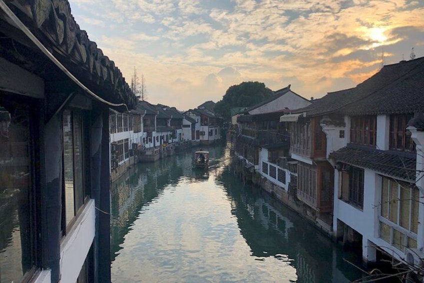 A narrow waterway flanked by traditional buildings with a boat in the distance. 2
