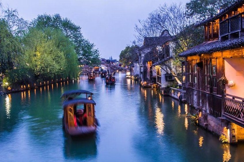 A traditional boat on a river, surrounded by historic buildings and trees. 5