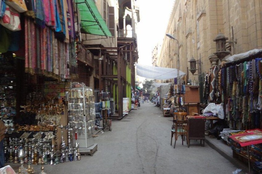 A narrow street lined with shops selling various items. 4