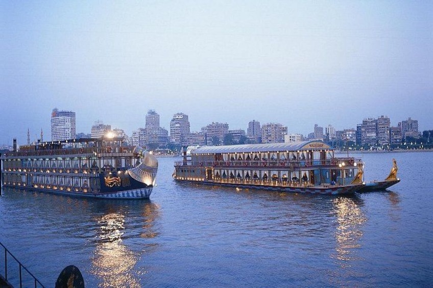 Two large riverboats with golden decorations, a city skyline in the background, and a calm water surface reflecting the boats. 2