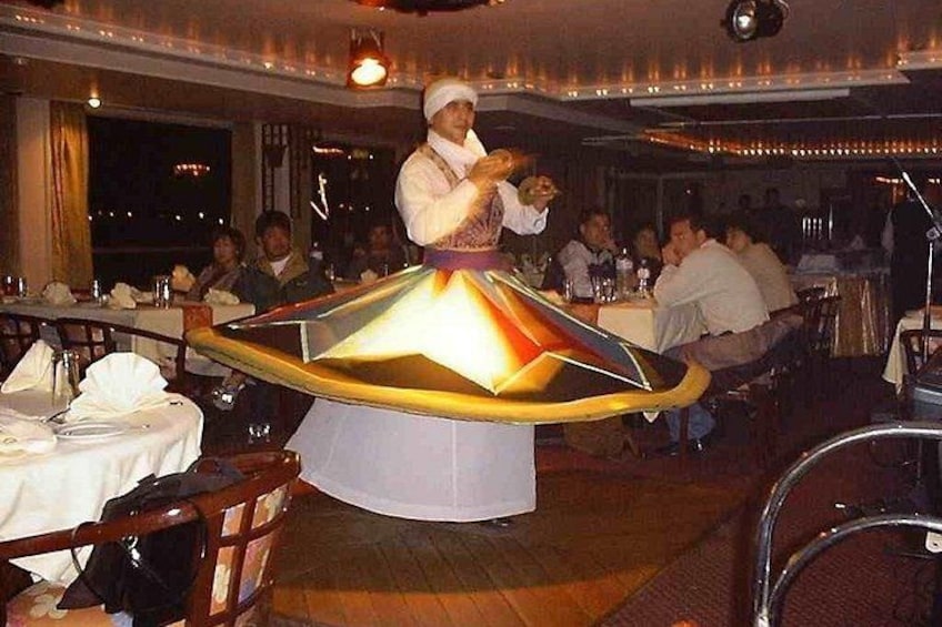 A restaurant interior with a central table featuring a unique, illuminated, conical design. 4