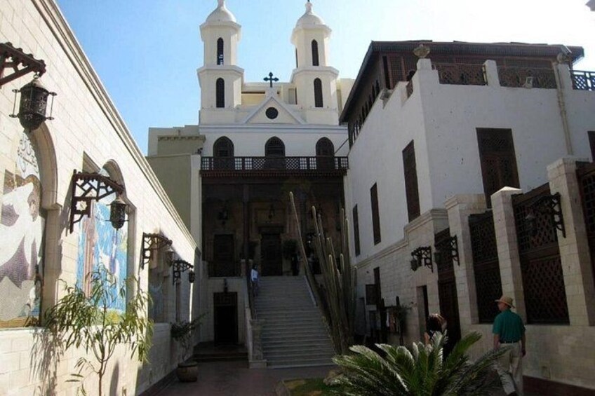 Una chiesa con un campanile, una scalinata che conduce all'ingresso e una persona che cammina. 3