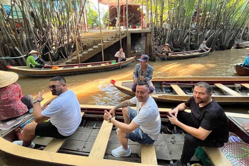 A group of people in a wooden boat on a river surrounded by mangrove trees. 5