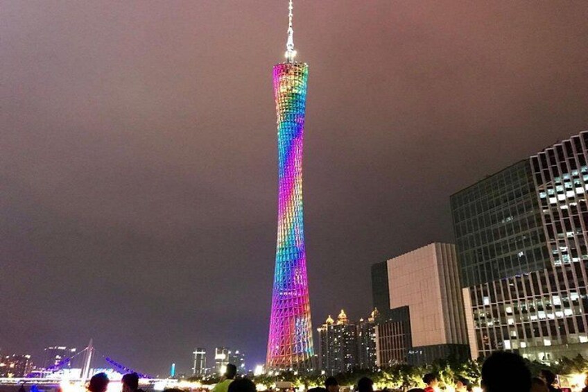 A tall building with a colorful light display at night. 1