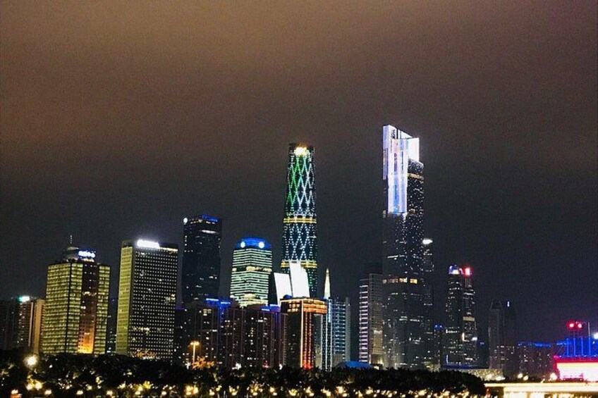 A city skyline at night with illuminated buildings and a prominent tower. 4