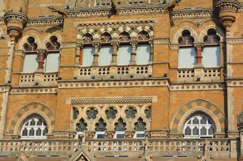 A detailed architectural facade with arched windows and ornate stonework. 5