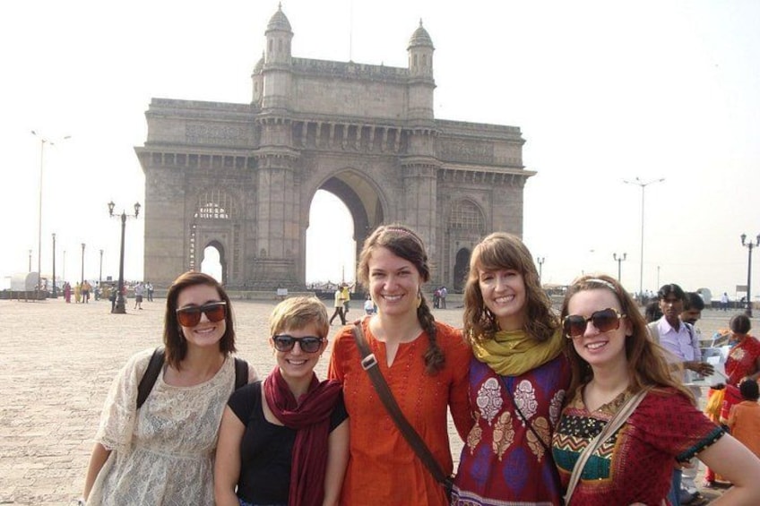 A group of people standing in front of the Gateway of India. 4