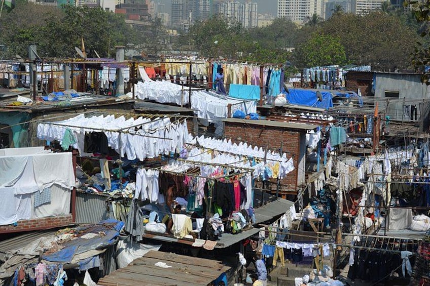 A densely packed urban slum with makeshift structures and clotheslines. 2