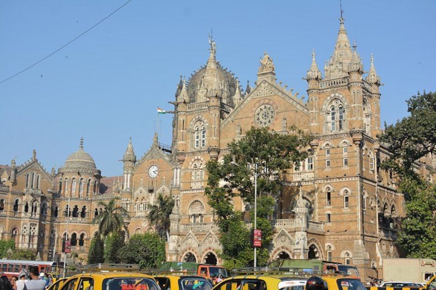 A historic building with multiple domes and spires, surrounded by trees and vehicles. 3