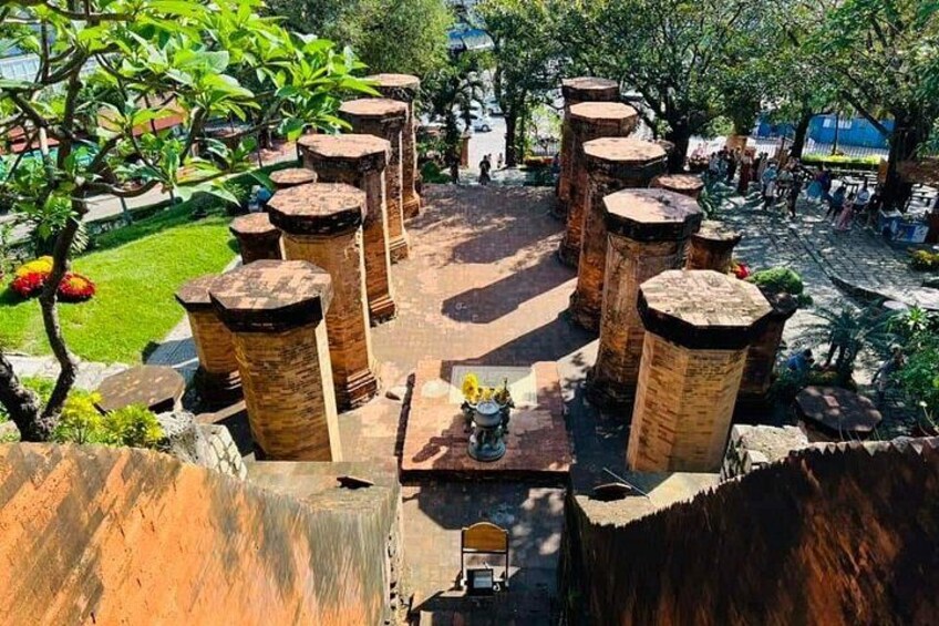 A courtyard with large stone columns, a central fountain, and surrounding greenery. 5
