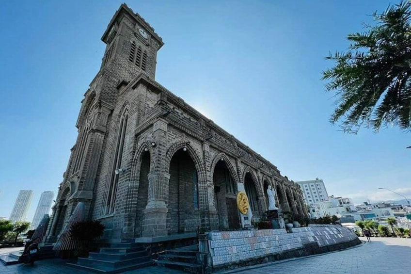 En stor, historisk kyrka med ett klocktorn, välvda fönster och en framträdande entré. 3