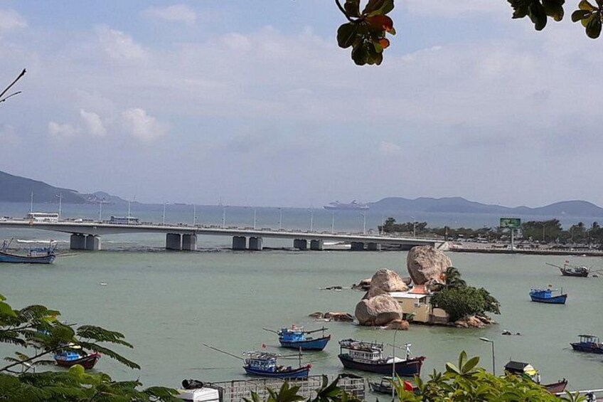 A coastal scene with boats, a bridge, and rocky formations. 3