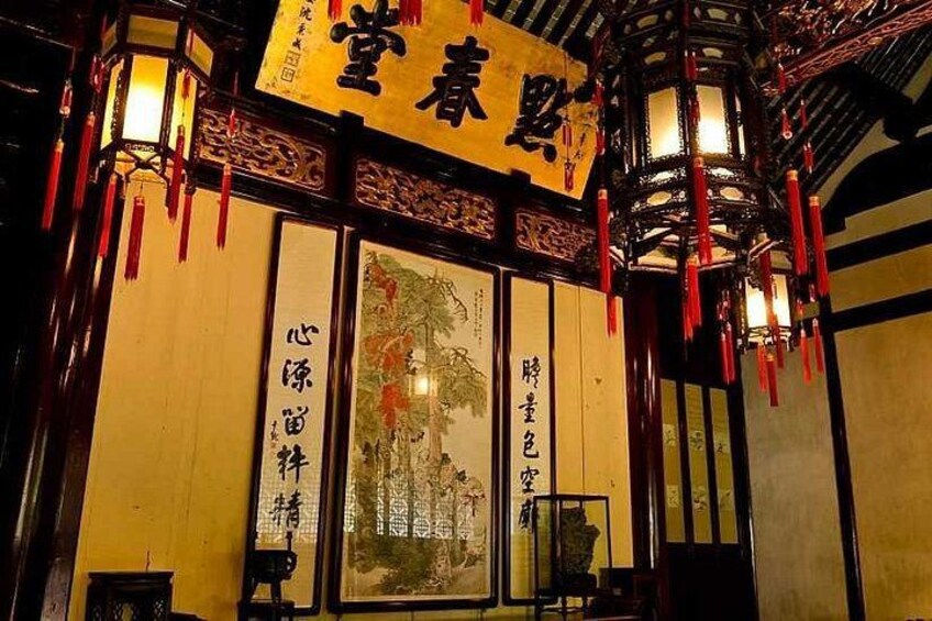 Un bâtiment traditionnel chinois, orné de lanternes rouges, d’un grand tableau encadré et de calligraphies chinoises sur les murs. 2