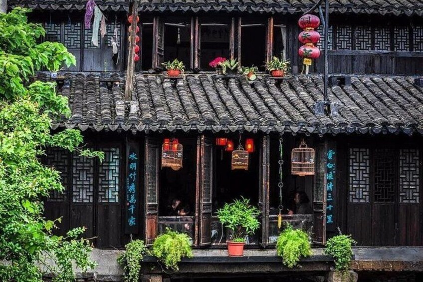A traditional Chinese building with tiled roofs, wooden lattice windows, and hanging lanterns. 2