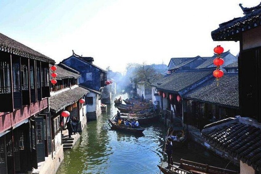 A traditional canal scene with narrow waterway, wooden buildings, and red lanterns. 1