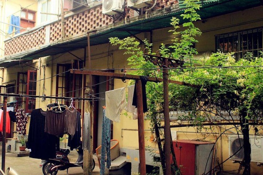 A residential area with a balcony, clothes hanging on a line, a motorcycle, and a tree. 5