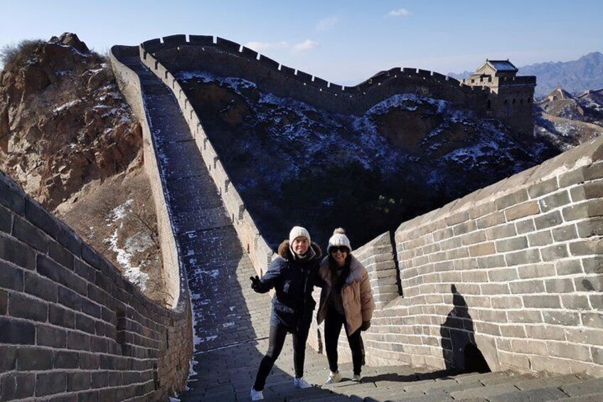 Una persona parada en la Gran Muralla China, con nieve en el suelo. 1