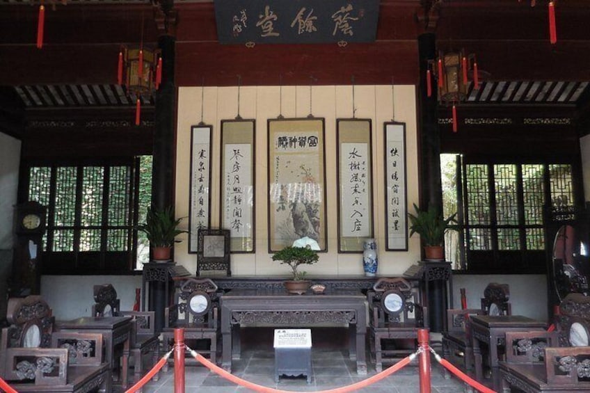 A traditional Chinese temple interior with wooden furniture, calligraphy scrolls, and red lanterns. 5