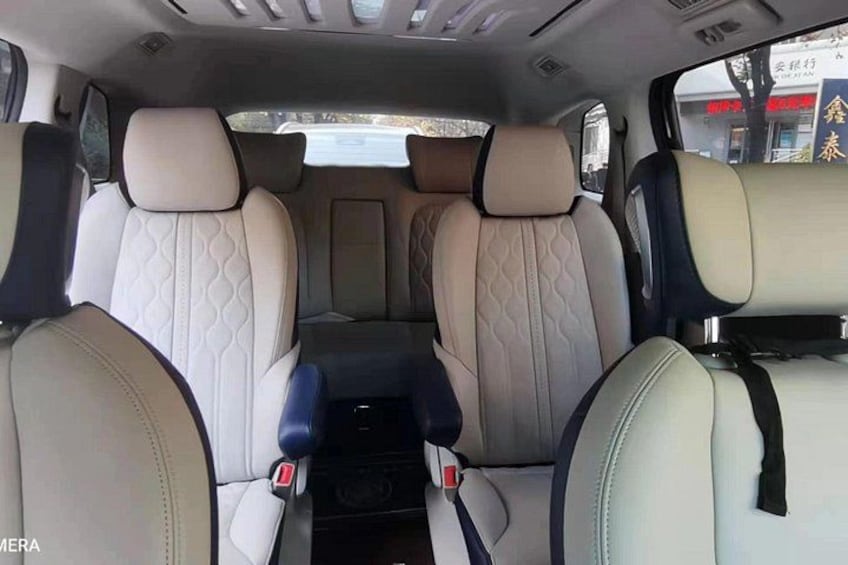 Interior de coche con asientos color beige y negro, consola central y espejo retrovisor. 5