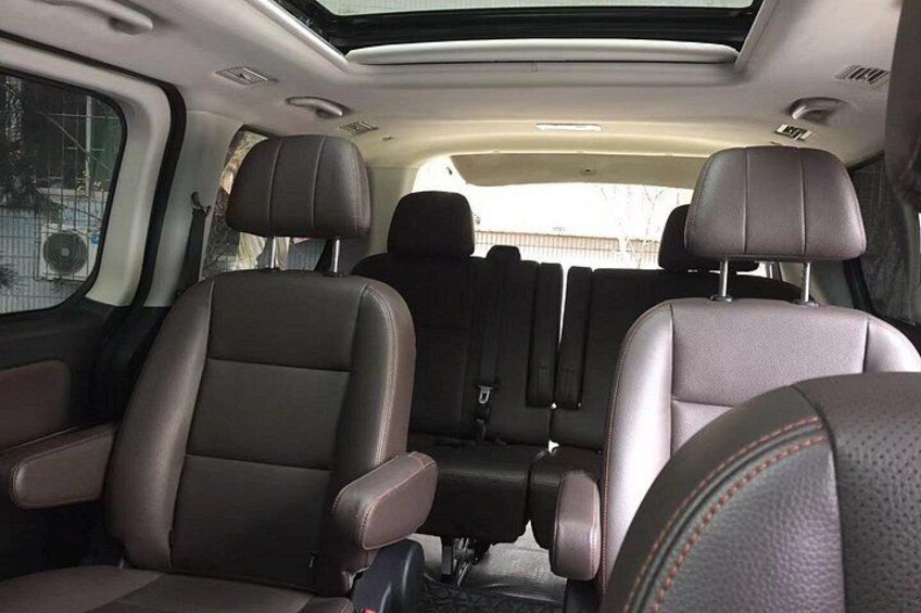 A car interior with leather seats and a sunroof. 2