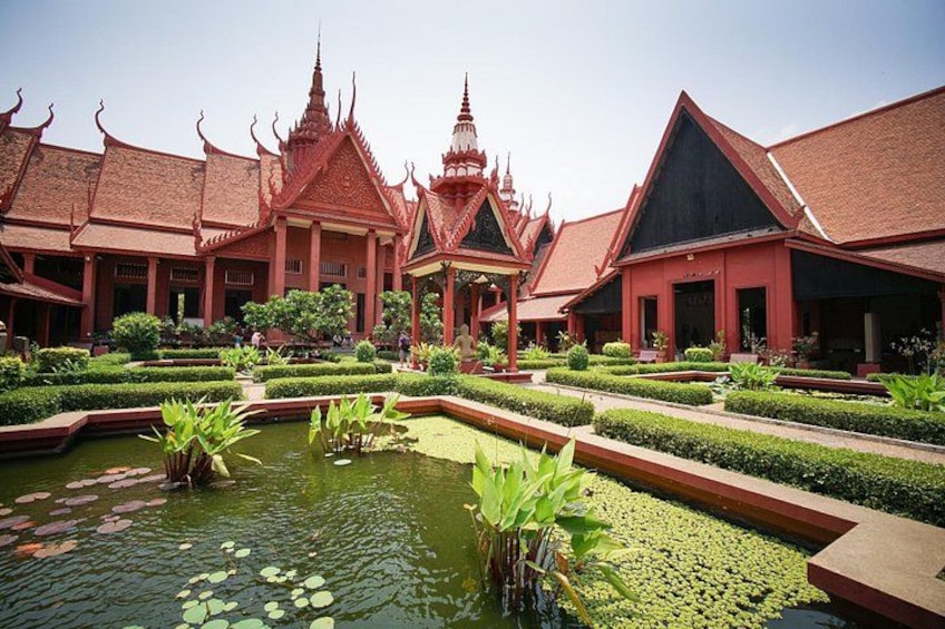 Een traditioneel Thais tempelcomplex met versierde architectuur, een vijver met waterlelies en goed onderhouden tuinen. 1