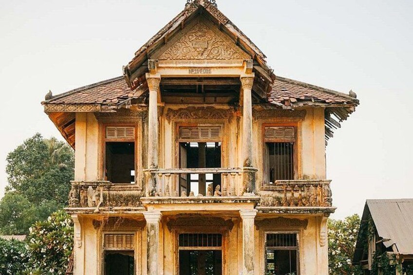 An old, ornate building with a tiled roof, multiple windows, and a balcony. 4