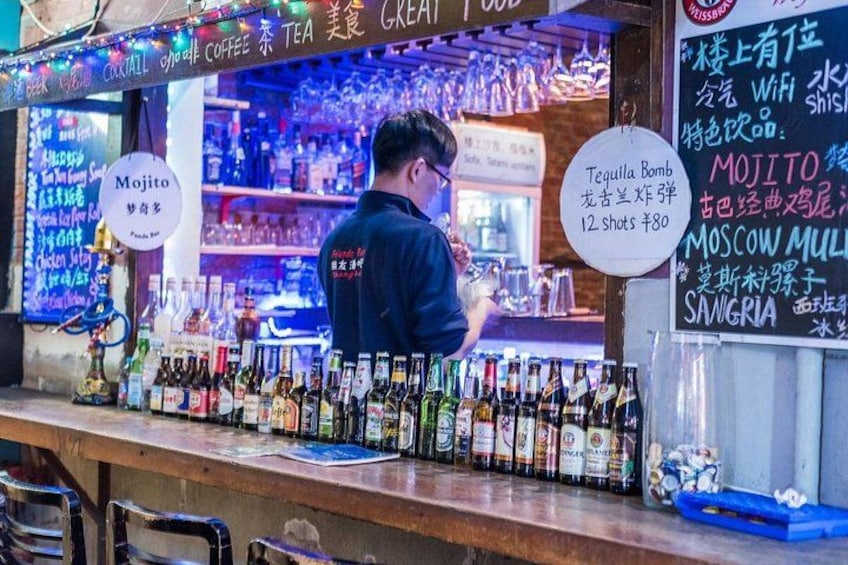 A bar with a variety of liquor bottles and a menu board. 5