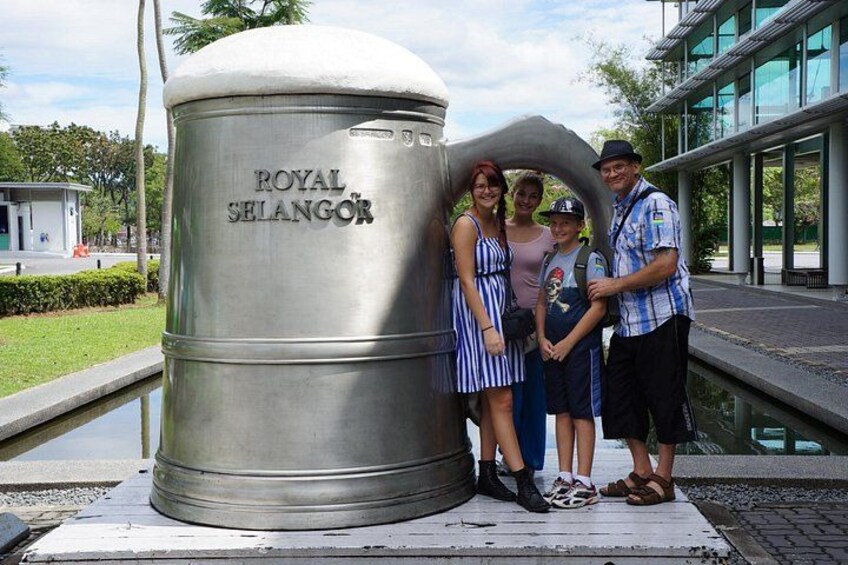 A family posing in front of a cylindrical monument labeled 'ROYAL SELANGOR.' 4