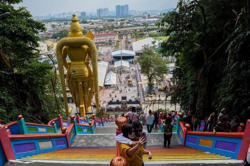 A large golden statue at the top of a staircase with colorful railings. 3