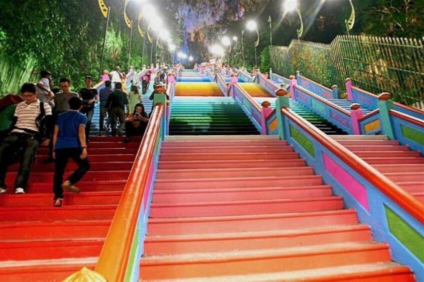 A brightly colored staircase with multiple steps leading upwards, surrounded by a fence and trees. 3