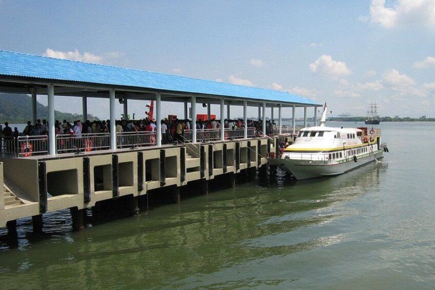 A ferry dock with a covered waiting area and a boat. 4