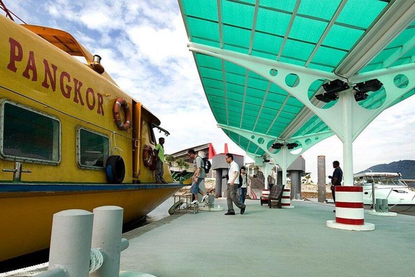 A yellow boat named PANGKOR docked at a pier with people boarding. 5