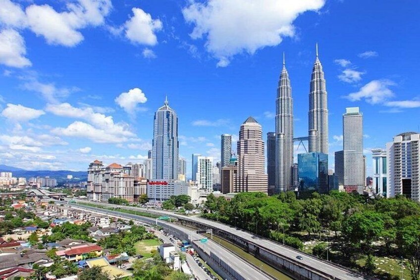 A cityscape with a prominent skyscraper, a highway, and surrounding greenery. 5