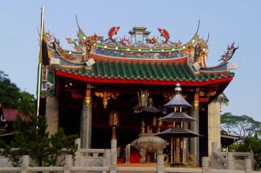 A traditional temple with ornate architecture, a tiled roof, and a central statue. 4