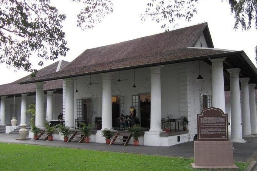 A colonial-style building with a covered porch, columns, and potted plants. 5