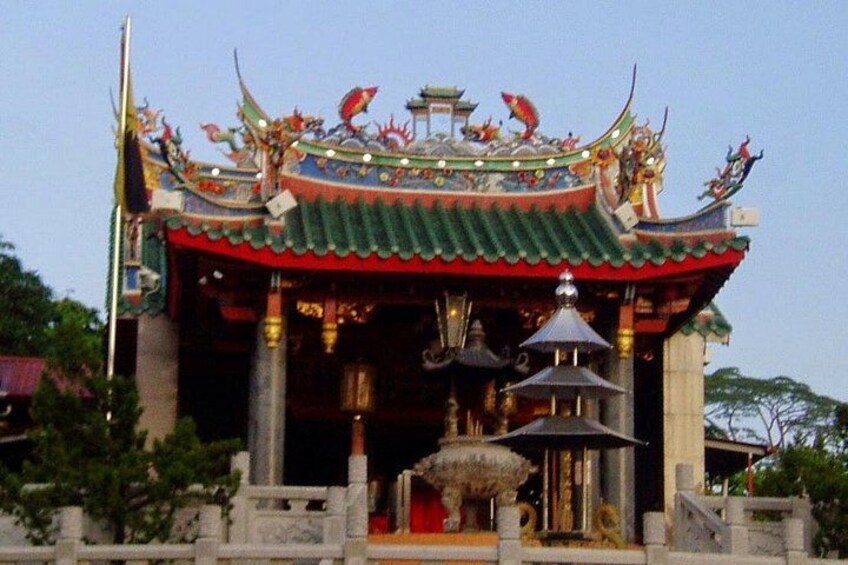 A traditional temple with ornate architecture, a large bell, and a statue. 3