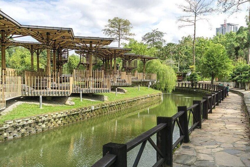 A riverside walkway with wooden bridges, stone steps, and a calm water body. 5
