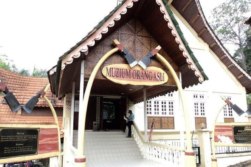 A building with a sign reading 'MUZIUM ORANG ASLI' and a traditional architectural style. 4