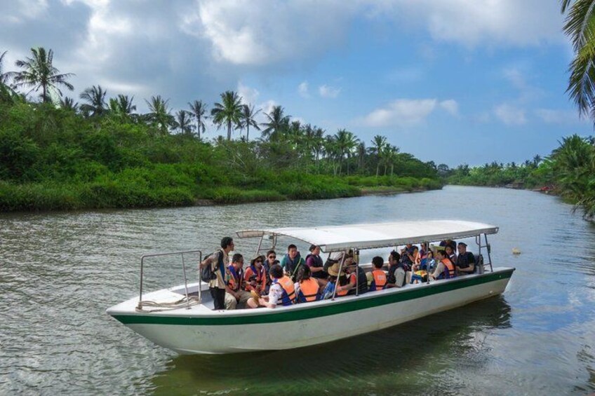 A boat with passengers on a river surrounded by greenery. 4