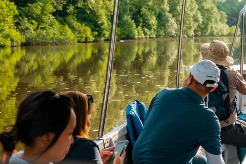 A river with boats, people wearing hats, and greenery in the background. 5