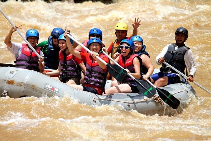 A group of people in a raft navigating through a river. 4