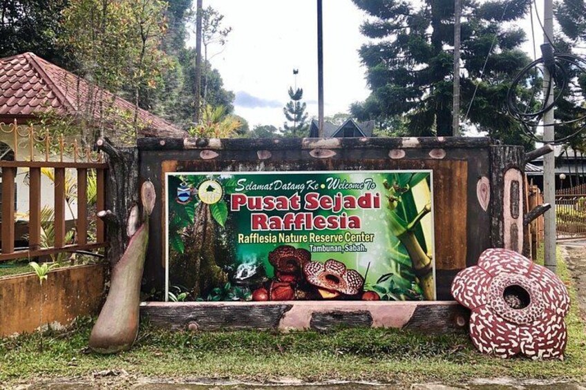 A sign for Pusat Sejati Rafflesia, a nature reserve center. 4