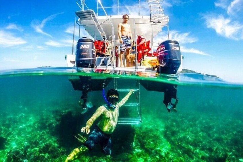A person snorkeling underwater near a boat with two outboard motors labeled 250. 5