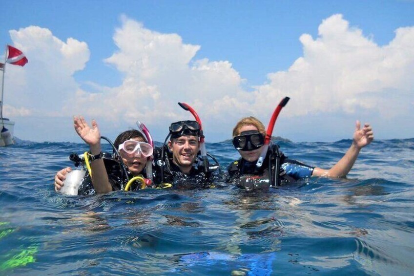 Three people snorkeling in the ocean with fins and masks. 1