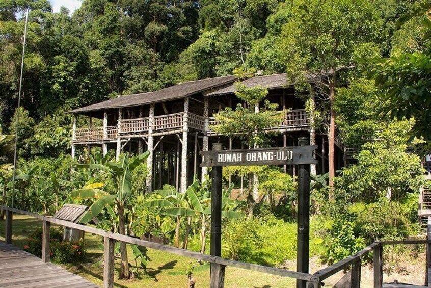 A wooden structure with a sign reading "Rumah Orang-Ulu" surrounded by lush greenery. 3