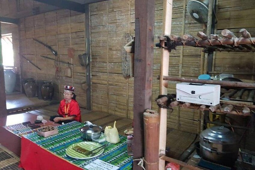 A traditional kitchen with a person in red, wooden walls, and various cooking utensils. 5