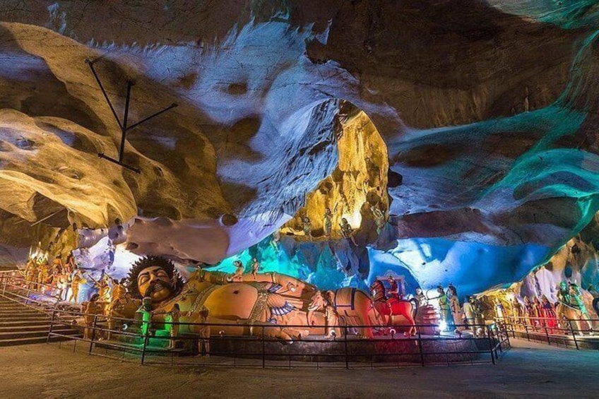 An ice cave with colorful lighting and a large sculpture of a man. 4