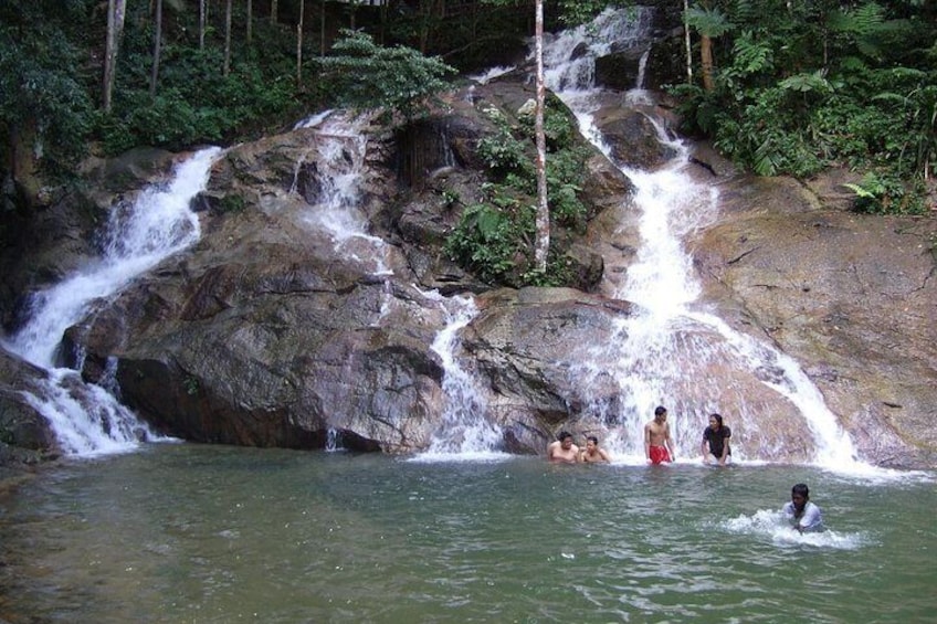 A waterfall with people swimming in the water below. 5