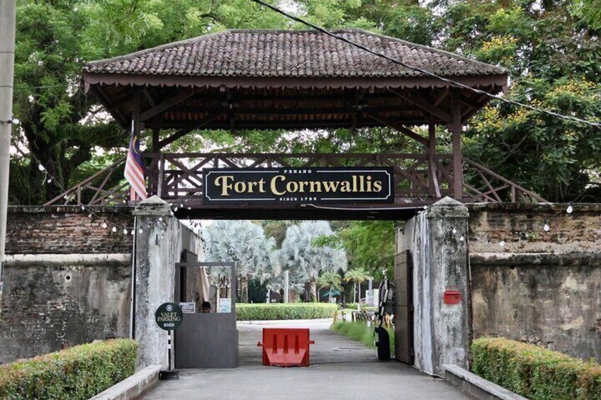 A sign for Fort Cornwallis with a tiled roof and a flag. 4